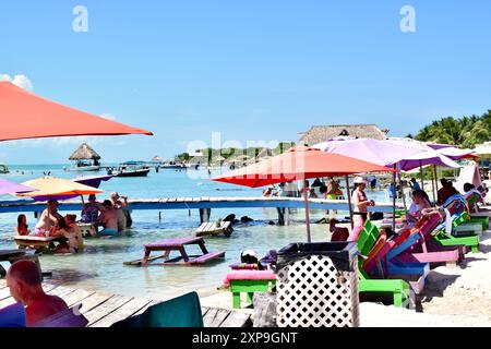 Touristes appréciant secret Beach à San Pedro, Belize. Les gens se relaxent dans des chaises longues sur le sable en été. Banque D'Images