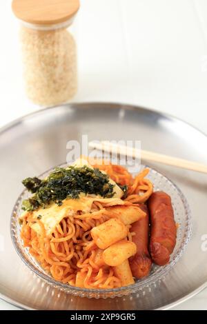 Rabokki, Topokki avec nouilles Ramyeon, saucisse et saucisse. Garniture avec fromage fondu et nori Banque D'Images