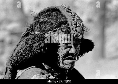Une vieille femme porte un perak plein de pierres précieuses dans le cadre de sa robe traditionnelle au Ladakh, Inde - 1988 Banque D'Images