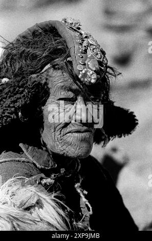 Une vieille femme porte un perak plein de pierres précieuses dans le cadre de sa robe traditionnelle au Ladakh, Inde - 1988 Banque D'Images