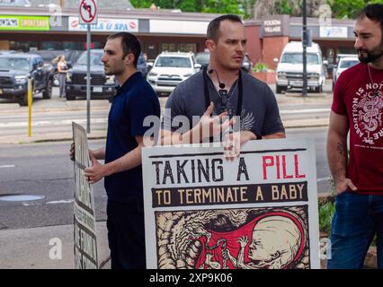 Trois militants du droit à la vie protestent contre des avortements médicaux à Boulder, Colorado trois hommes portant des pancartes portant des messages anti-avortement se tiennent sur un trottoir Banque D'Images