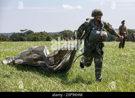 Un parachutiste autrichien traîne son MC-6 Parachute alors qu'il court vers le X lors du Leapfest 2024 à Glenrock Drop zone, Exeter, Rhode Island, le 3 août 2024. Leapfest est le plus grand événement international de formation de parachute de ligne statique et compétition organisé par le 56th Troop Command, Rhode Island Army National Guard pour promouvoir la formation technique de haut niveau et l'esprit de corps au sein de la communauté aéroportée internationale. (Photo de la réserve de l'armée américaine par le Sgt. 1re classe Austin Berner) Banque D'Images