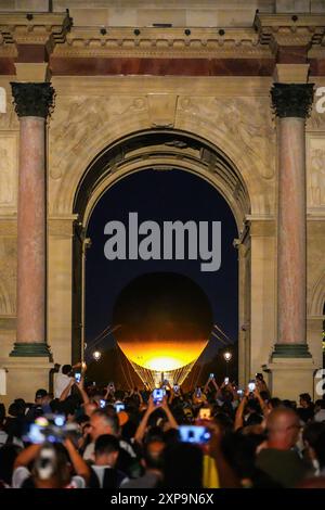 Paris, France - 2 août 2024 : ballon captif à flamme olympique sous l'Arc de Triomphe du Carrousel (Arc de Triomphe du Carrousel) dans la Tuilerie Banque D'Images