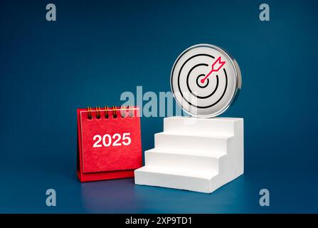 Objectif commercial du nouvel an, concept financier et technologique. Icône de cible chromée 3d sur l'escalier blanc de la plus haute marche comme les étapes du graphique de croissance près de 2025 bureau calen Banque D'Images