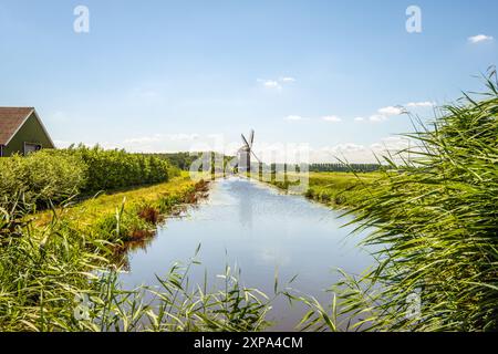 Large fossé avec le Peilmolen au bout, un moulin à polder de type sailer à sol rond, construit en 1824 pour drainer le Zuidzijderpolder près du village de Oud-Alblas en Hollande du Sud jusqu'en 1971. Le moulin appartient à SIMAV et, après une restauration, il est à nouveau opérationnel. ANP / Hollandse Hoogte / Ruud Morijn pays-bas Out - belgique Out Banque D'Images