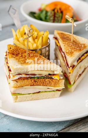 Sandwich club de poulet avec frites, ketchup, moutarde et mayonnaise Banque D'Images