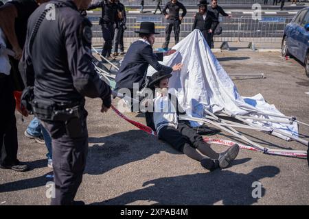 Tel Aviv, Israël. 05 août 2024. Les ultra orthodoxes bloquent l’entrée du centre central de recrutement. Aujourd’hui, c’est le premier jour de recrutement pour les orthodoxes comme l’a décidé le tribunal israélien. Crédit : Ilia Yefimovich/dpa/Alamy Live News Banque D'Images