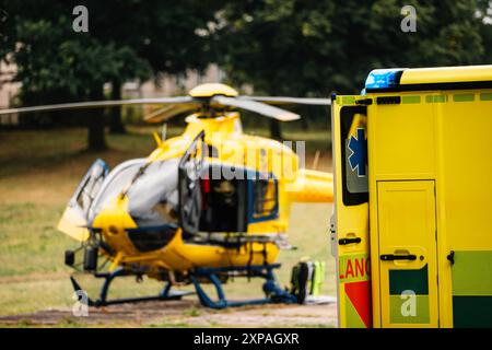 Focalisation sélective sur le clignotant de lumière bleue sur la voiture ambulance du service médical d'urgence contre hélicoptère. Thèmes sauvetage, urgence et soins de santé. Banque D'Images