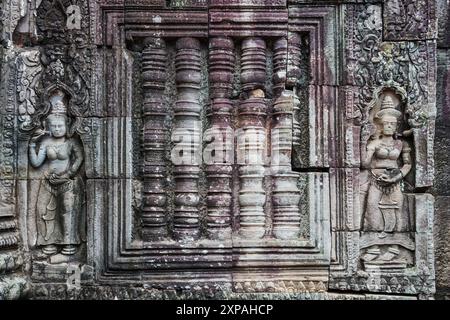 Mur du temple de TA Prohm décoré de colonnes en fenêtre aveugle et de reliefs d'apsaras sur les côtés à Siem Reap, Cambodge. Banque D'Images