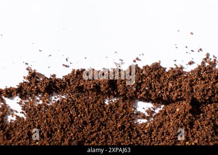 Café naturel moulu dispersé sur fond blanc. Banque D'Images