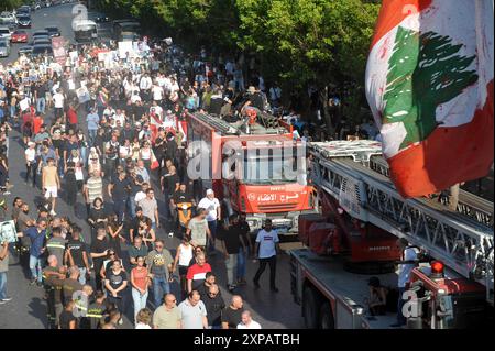 Beyrouth, Liban. 4 août 2024. Les gens commémorent le quatrième anniversaire des explosions du port de Beyrouth en 2020 à Beyrouth, Liban, le 4 août 2024. Les familles des victimes des attentats meurtriers du port de Beyrouth de 2020 ont commémoré dimanche le quatrième anniversaire de l'incident avec deux marches dans le centre-ville de Beyrouth et un rassemblement devant les silos du port. Plusieurs familles ont prononcé des discours qui ont souligné la nécessité de mener à bien l'enquête, de publier un acte d'accusation dans l'affaire et de nommer les responsables des explosions. Crédit : Bilal Jawich/Xinhua/Alamy Live News Banque D'Images