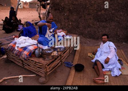 Les hommes boivent du thé et se détendent dans leurs huttes dans un camp de nomades touaregs près de Tombouctou, en Afrique de l'Ouest. Banque D'Images