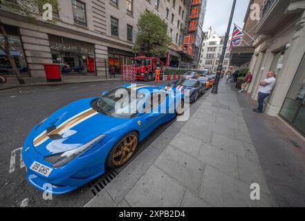 Stratton Street, Mayfair, Londres, Royaume-Uni. 5 août 2024. Une ligne de six voitures de sport de luxe (Ferrari, Lamborghini, Porsche) sont garées à l'extérieur du Mayfair, chacune récupérant apparemment des tickets de stationnement au fur et à mesure que la matinée se prolonge. Crédit : Malcolm Park/Alamy Live News Banque D'Images