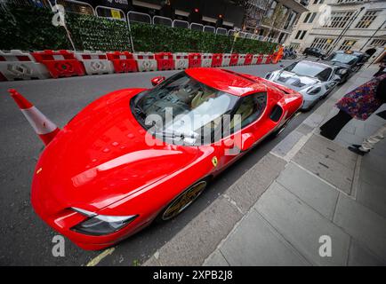 Stratton Street, Mayfair, Londres, Royaume-Uni. 5 août 2024. Une ligne de six voitures de sport de luxe (Ferrari, Lamborghini, Porsche) sont garées à l'extérieur du Mayfair, chacune récupérant apparemment des tickets de stationnement au fur et à mesure que la matinée se prolonge. Crédit : Malcolm Park/Alamy Live News Banque D'Images