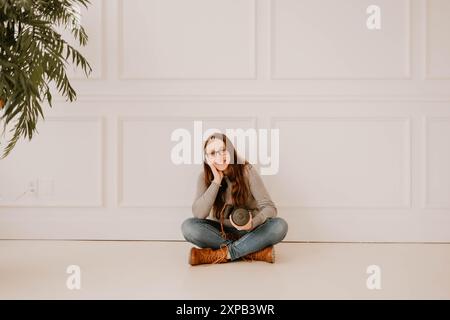 Photographe hispanique souriante tenant un appareil photo Banque D'Images