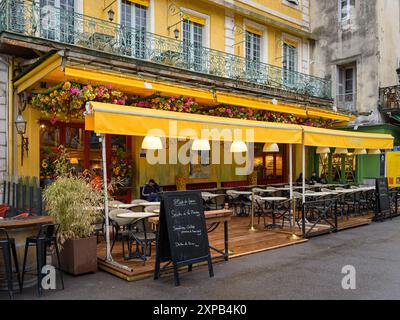 Arles, France - 3 mars 2023 : le Café Van Gogh sur la place du Forum par une journée nuageuse au printemps Banque D'Images