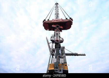 Frein, Allemagne. 05 août 2024. La grue portuaire mobile (LHM 550) d’une capacité de levage de 154 tonnes attend le chargement des locomotives électriques. Tout est encore au repos à Niedersachsenkai dans le port. Deux locomotives électriques échouées de Rail Cargo Carrier Germany GmbH (RCC) doivent être transportées par mer sur le bateau de navigation intérieure ELKA à l'aide de deux grues portuaires mobiles, probablement à 6 heures du matin le 7 août 2024. La route des locomotives a été coupée en raison d'un incendie de pont. Crédit : Lars Penning/dpa/Alamy Live News Banque D'Images