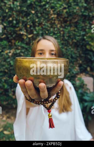 femme non reconnue jouant au bol de chant tibétain Banque D'Images