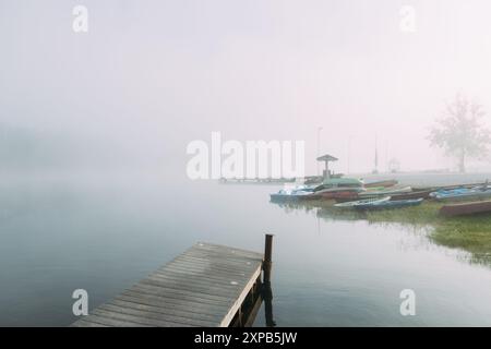 Scène matinale brumeuse de kayaks et de canoës au quai de bateau Banque D'Images