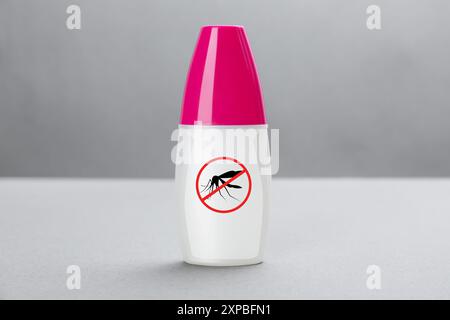 Spray moustique sur fond gris. Insectifuge Banque D'Images