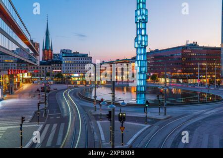 Centre-ville de Stockholm, place Sergel la nuit. Longue exposition, traînées de lumière de voiture, lumière du coucher du soleil, bâtiments à lumière montante Banque D'Images