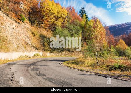 route de campagne asphaltée en montagne en automne. forêt sur la colline en feuillage d'automne. temps ensoleillé. road trip à travers la campagne de l'ukraine Banque D'Images