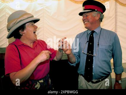 Rire mari et femme riant ensemble, s'amusant, étant idiot. Rosina & Peter Steer tromper autour avec quelques chapeaux, qui sont pour la vente aux enchères. Newnham, Northamptonshire, Angleterre juillet années 1994 1990 Royaume-Uni. HOMER SYKES Banque D'Images