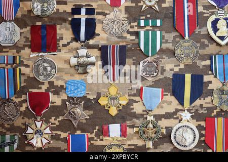 KIEV, UKRAINE - 10 JUILLET 2024 de nombreuses médailles militaires américaines sur fond de camouflage. Les États-Unis décernent des médailles. Accessoires de théâtre en papier faits à la main en gros plan Banque D'Images