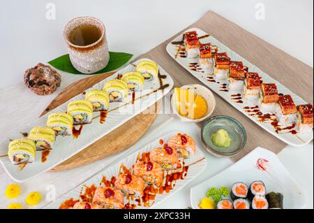 Vue de dessus du plateau en céramique avec une variété de rouleau de sushi au saumon avec des légumes, rouleau d'avocat, anguille grillée unagi, repas appétissant dans un restaurant japonais Banque D'Images