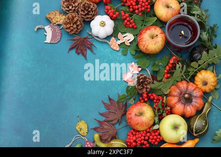 Pommes, citrouilles, cônes, feuilles, baies de rowan sur une table. Photo vue de dessus de la composition d'automne. Concept de saison de récolte. Banque D'Images