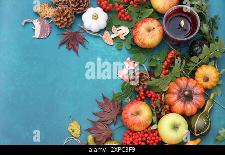 Pommes, citrouilles, cônes, feuilles, baies de rowan sur une table. Photo vue de dessus de la composition d'automne. Concept de saison de récolte. Banque D'Images