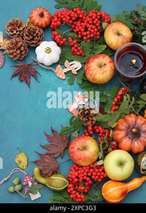 Pommes, citrouilles, cônes, feuilles, baies de rowan sur une table. Photo vue de dessus de la composition d'automne. Concept de saison de récolte. Banque D'Images