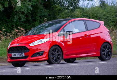 Whittlebury, Norhants, Royaume-Uni - 4 août 2024. Voiture Ford Fiesta rouge 2017 conduisant sur une route de campagne britannique Banque D'Images