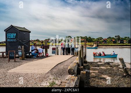 Touristes embarquant sur le bateau à rames opérant sur la rivière Blyth de Southwold à Walberswick, Suffolk, Royaume-Uni Banque D'Images