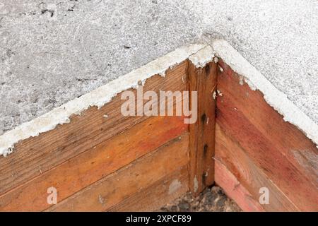 Un coin d'une fondation en coffrage en bois avec du béton fraîchement posé. La maison rurale est en construction Banque D'Images