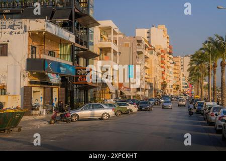 La rue près du front de mer Sour à Tyr, Liban, moyen-Orient, avec le trafic et les palmiers. Banque D'Images