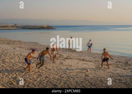 Les jeunes hommes arabes jouant au football (football) sur la plage de Tyr (Sour), la ville balnéaire au sud du Liban. Banque D'Images