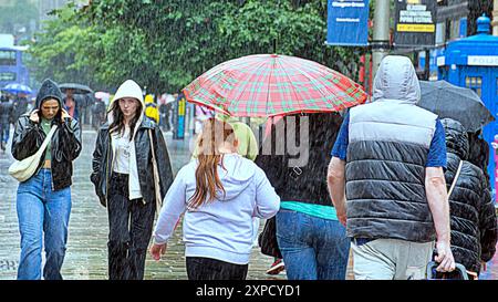 Glasgow, Écosse, Royaume-Uni. 5 août 2024. Météo britannique : pluie torrentielle avec une prévision pour plus de vues les habitants et les touristes se cachent sous des parasols dans le centre-ville. Crédit Gerard Ferry/Alamy Live News Banque D'Images