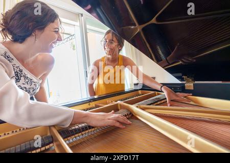 Professeur de piano enseignant à une adolescente le fonctionnement interne d'un piano à queue Banque D'Images