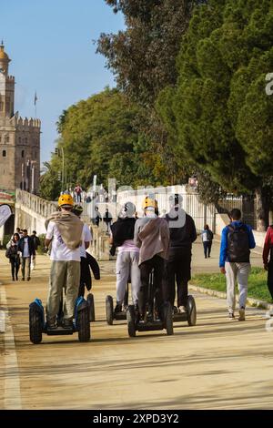 Séville, Espagne. 7 février 2024 - touristes circulant en segways vers Torre del Oro Banque D'Images
