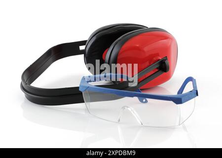 Casque antibruit et lunettes de sécurité sur blanc avec réflexion Banque D'Images