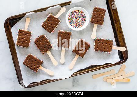 Le sandwich à la crème glacée saute sur une plaque à pâtisserie doublée de parchemin. Banque D'Images