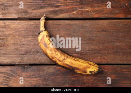 Banane surmûre avec des taches sombres sur la table en bois blanc, vue de dessus Banque D'Images