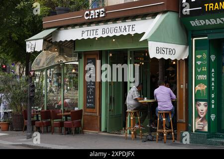 Paris, France - 07 juin 2024 : petit café bistrot avec des gens qui prennent un café. Banque D'Images