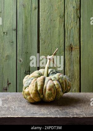 Citrouille d'héritage chinois ou courge d'hiver sur une vieille table rustique avec fond vert Banque D'Images