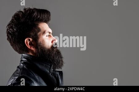 Modèle masculin avec cheveux élégants, barbe. Homme sérieux avec une longue barbe et moustache. Mode de coiffeur et beauté. Homme barbu avec coiffure élégante en noir Banque D'Images