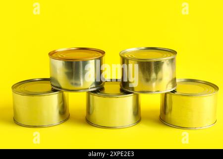 Boîtes de conserve avec poisson sur fond jaune Banque D'Images