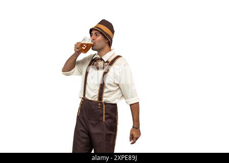 Jeune homme bavarois vêtu d'une tenue traditionnelle, dégustant une bière fraîche pendant l'Oktoberfest. capture l'essence de la célébration, de la tradition et de la joie Banque D'Images