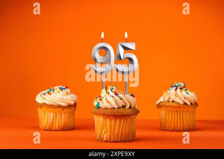 Bougie numéro 95 - célébration avec cupcake d'anniversaire sur fond orange Banque D'Images