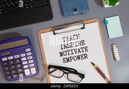 Cahier ouvert avec texte enseigner inspirer motiver Empower sur fond de bois Banque D'Images